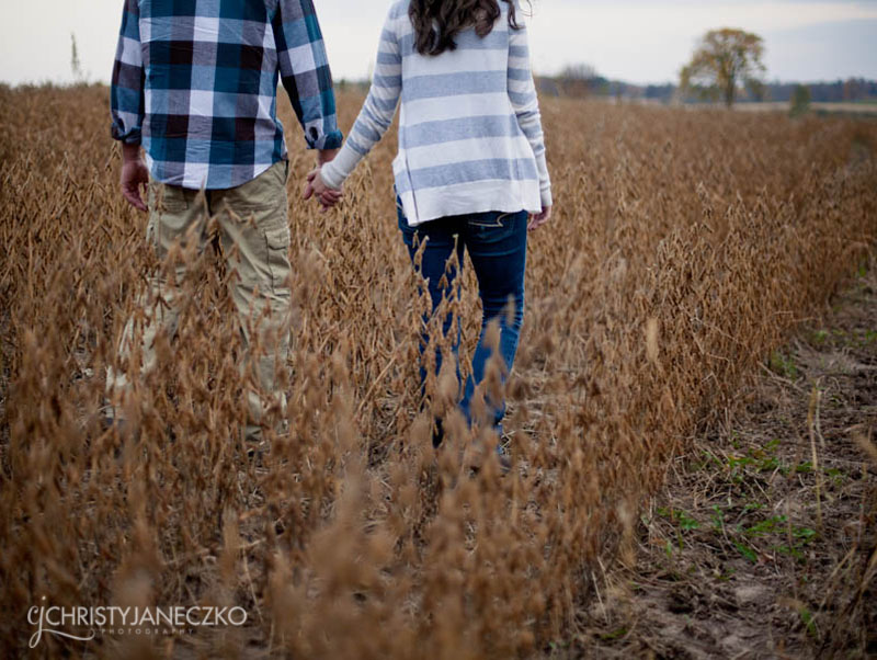 holding hands in a field of soybeans