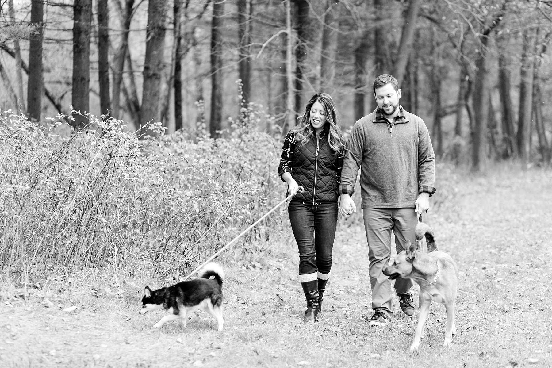 couple in black and white photo walking their dogs in Chippewa Falls