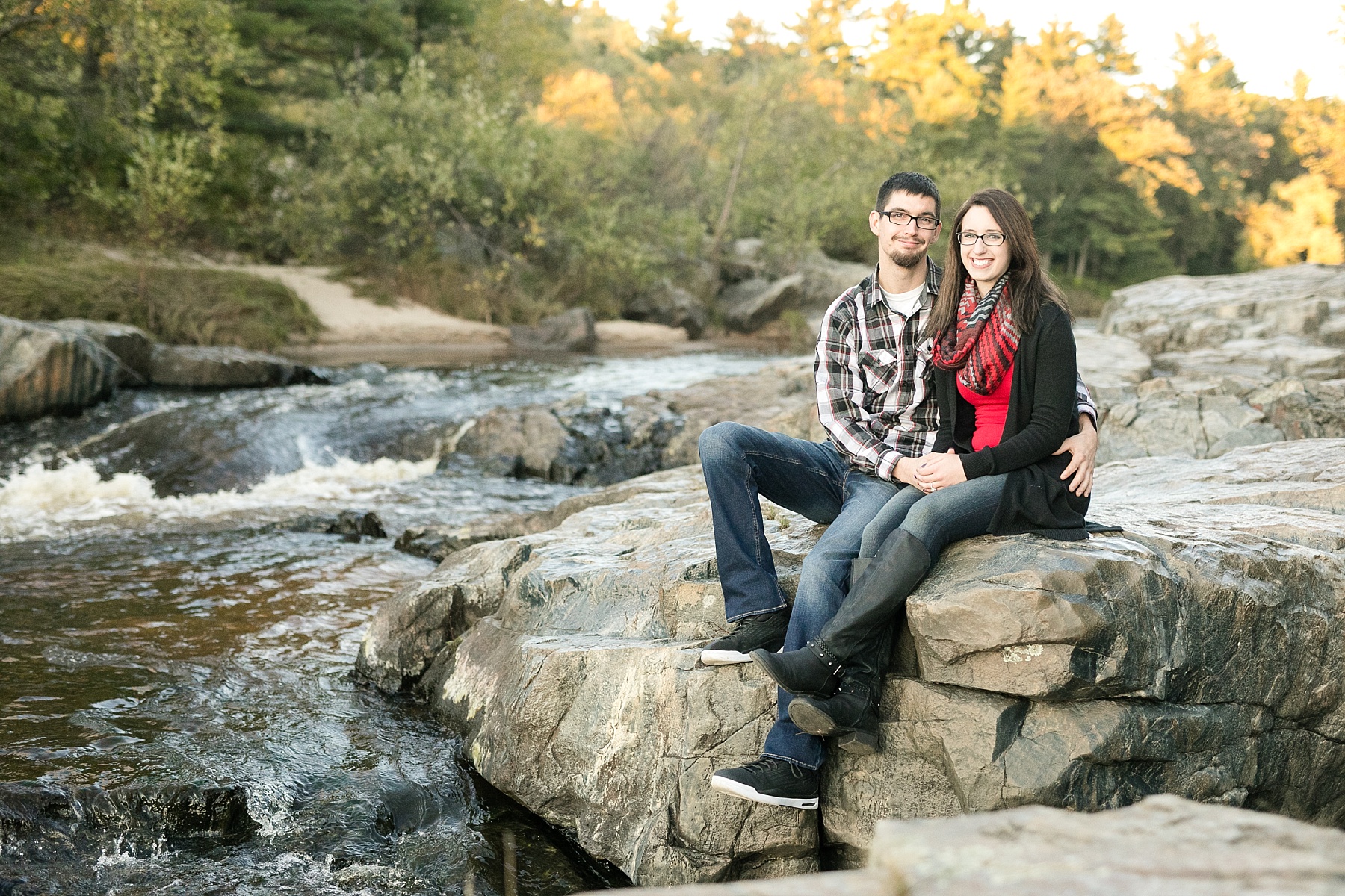 Couple sitting on the rocks at Big Falls in Eau Claire.
