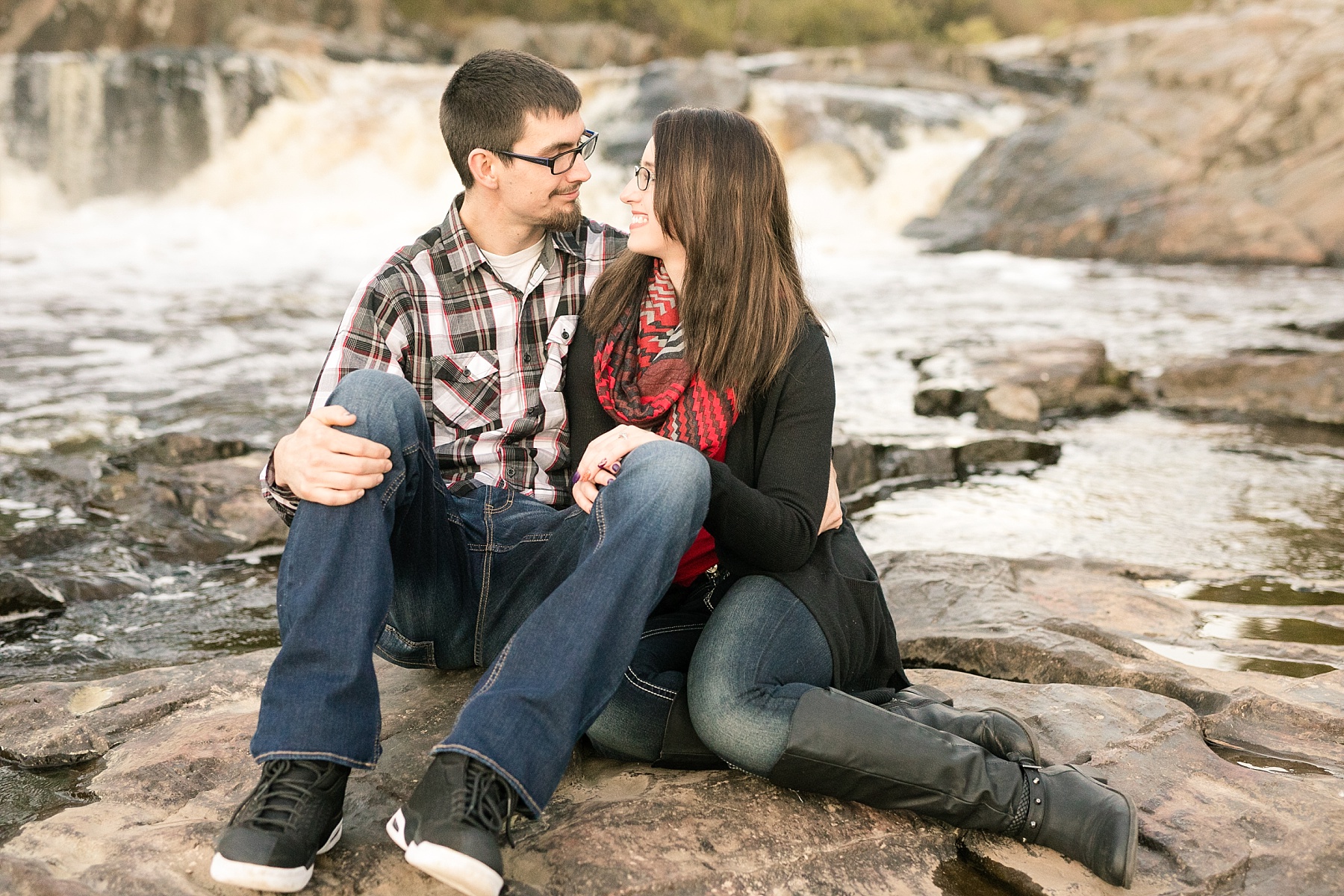Couple sitting on the rocks near the waterfall at Big Falls