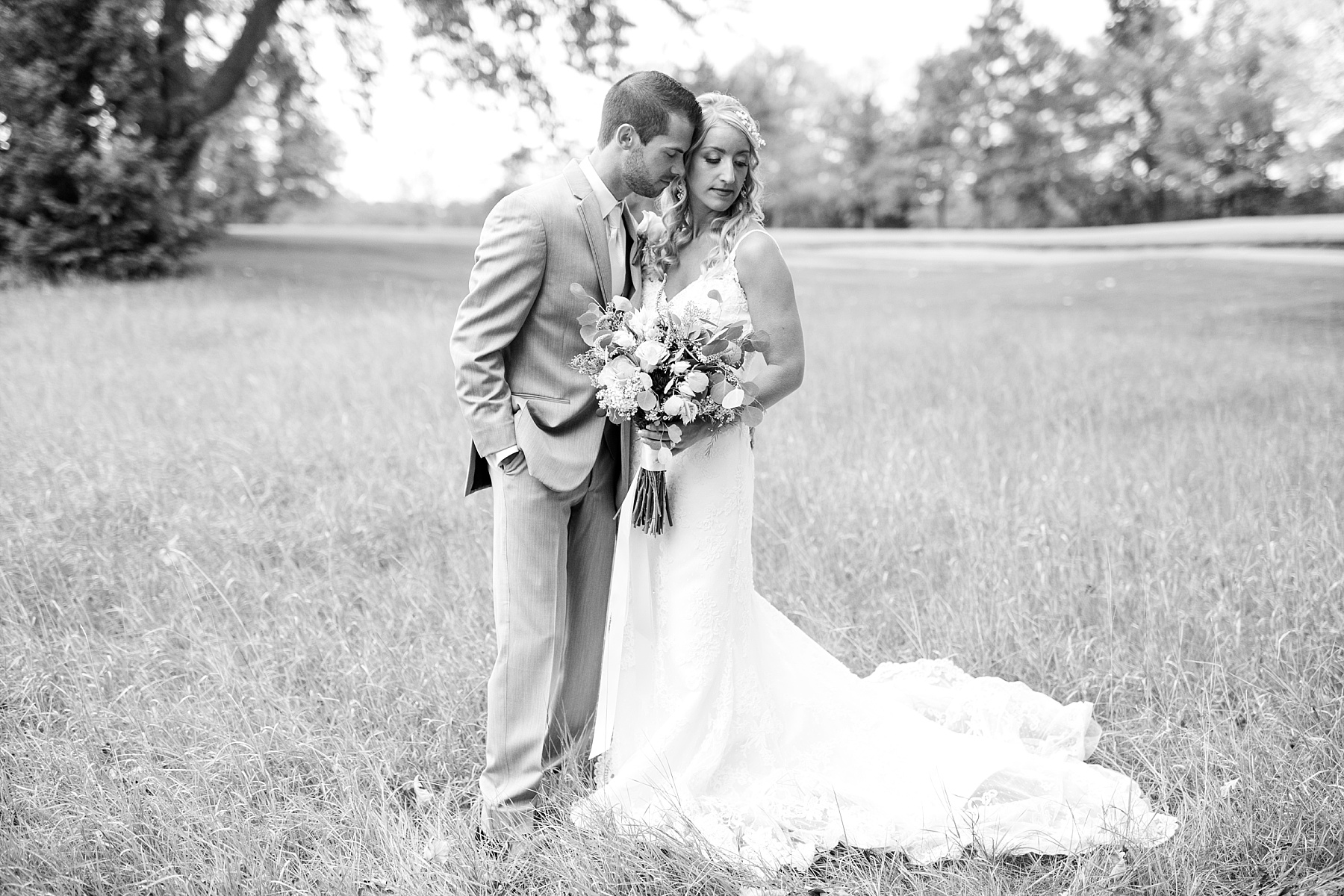 bride and groom in a field on a golf course