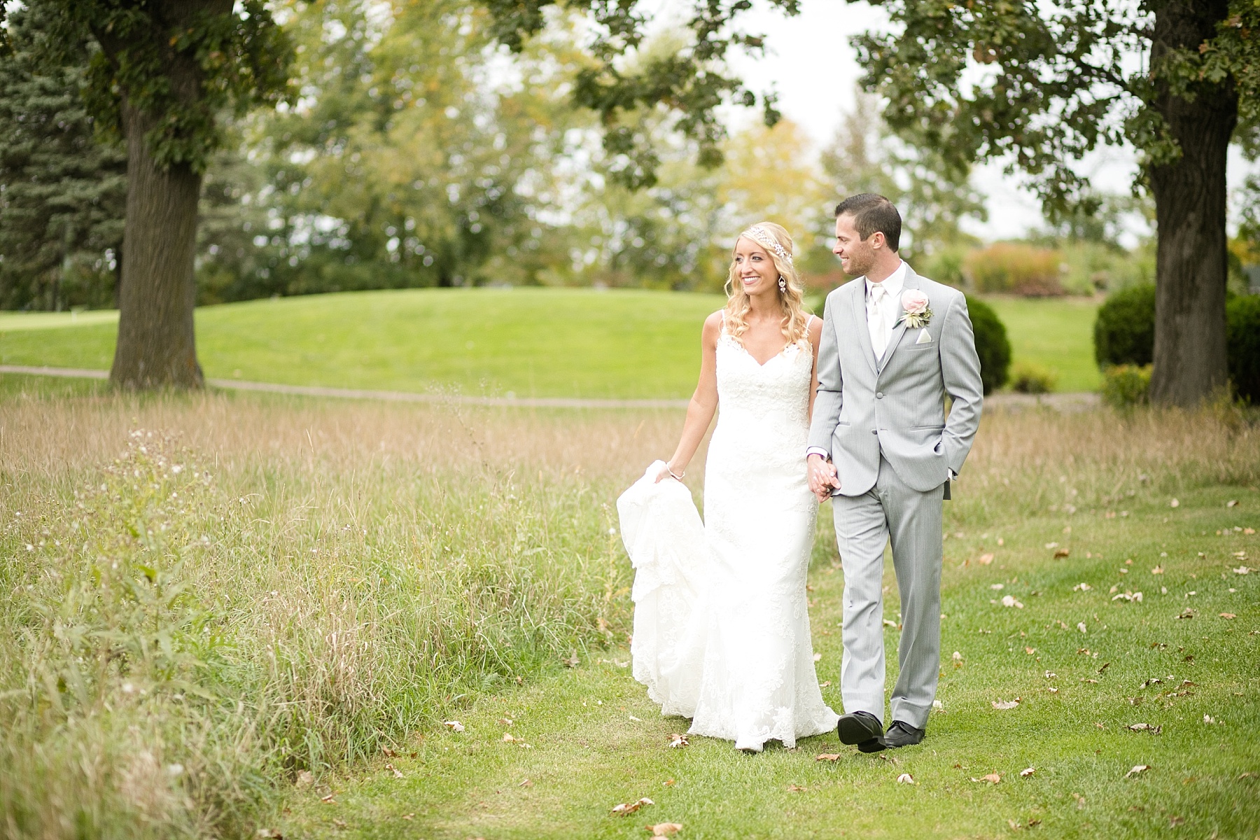 bride and groom walking together at Lake Wissota Golf & Events
