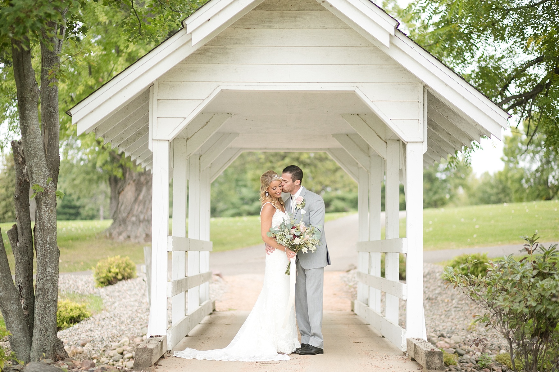 bride and groom on white bridge at Lake Wissota Golf & Events