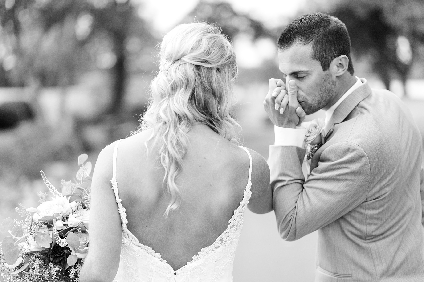 groom kissing brides hand at Lake Wissota Golf & Events