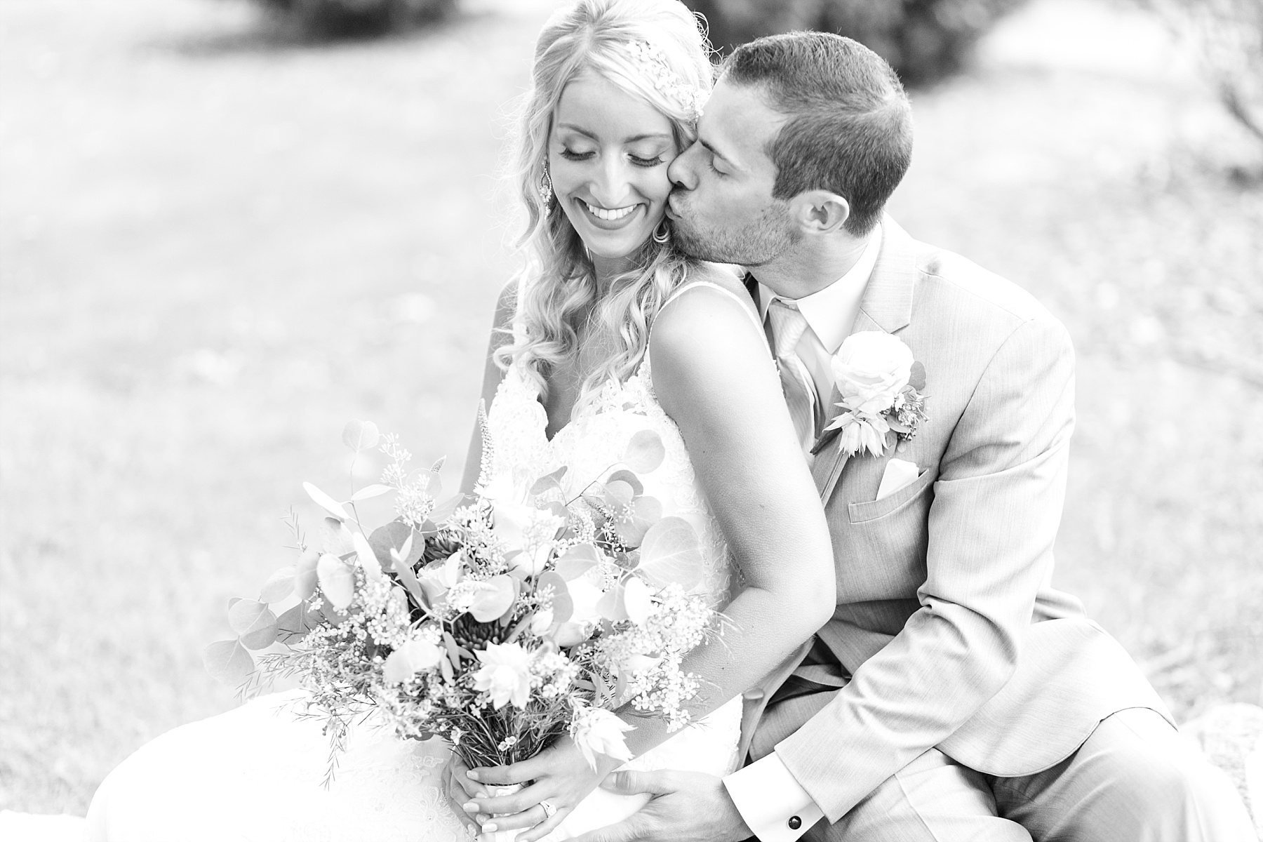 bride and groom sitting down in black and white photo 