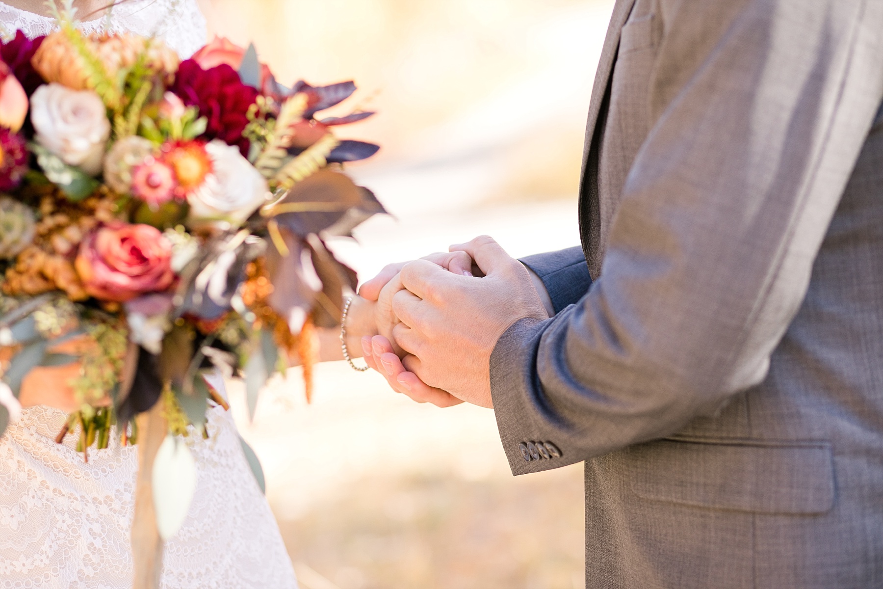 bride and grooms hands with bouquet