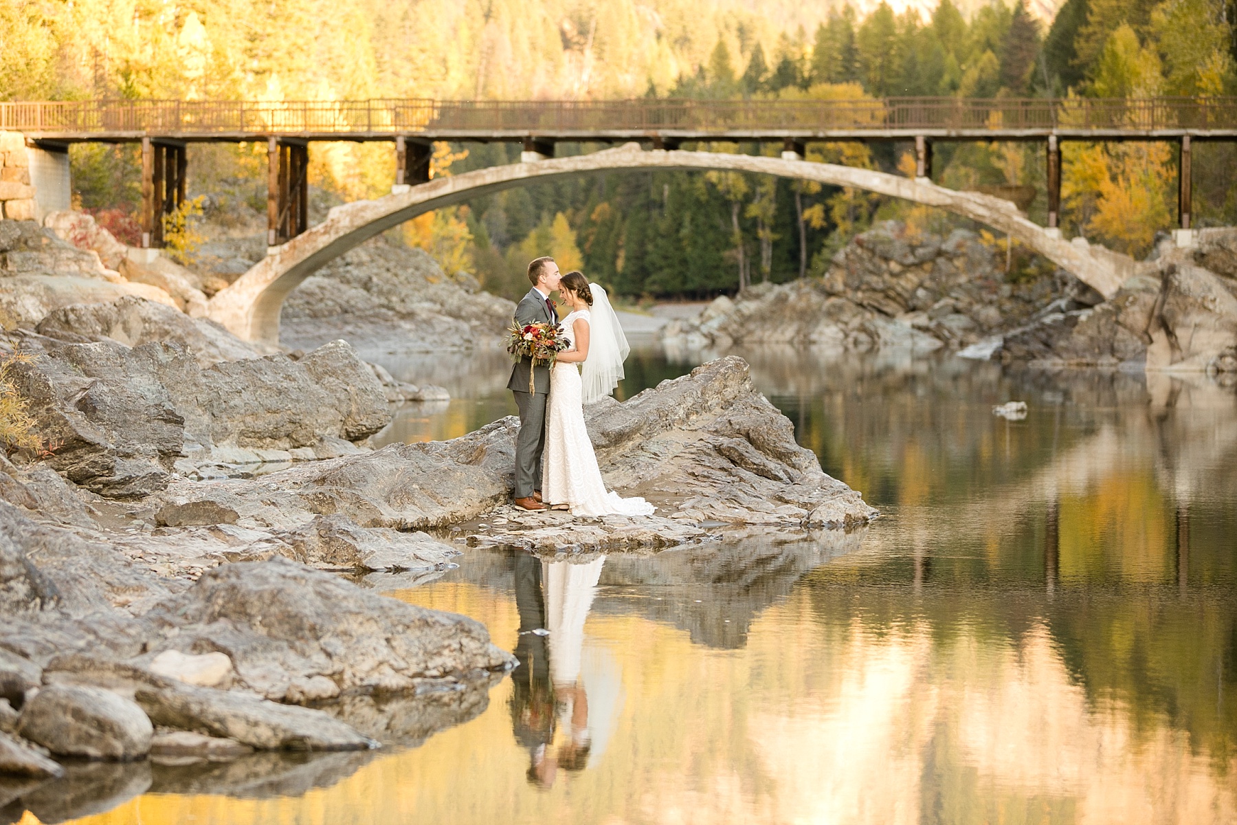 bride and groom reflection in stream Glacier National Park elopement