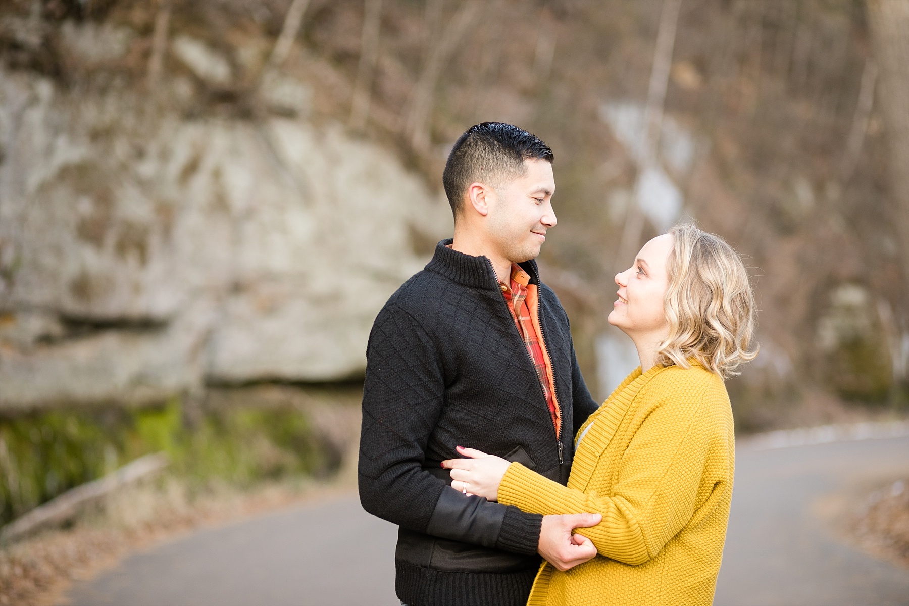 Couple looking at each other for their fall engagement photos.