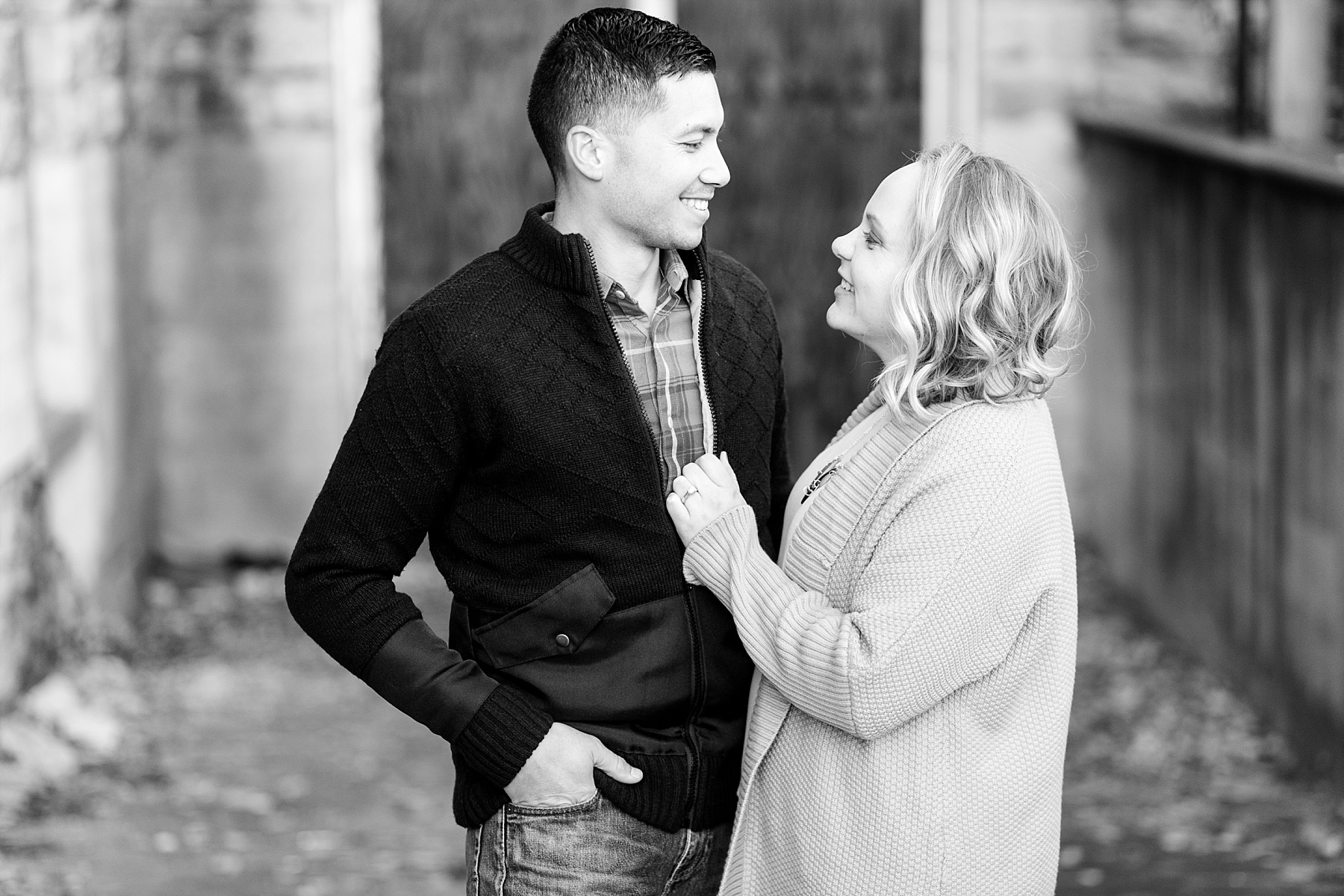 Black and white photo of a couple smiling at each other.