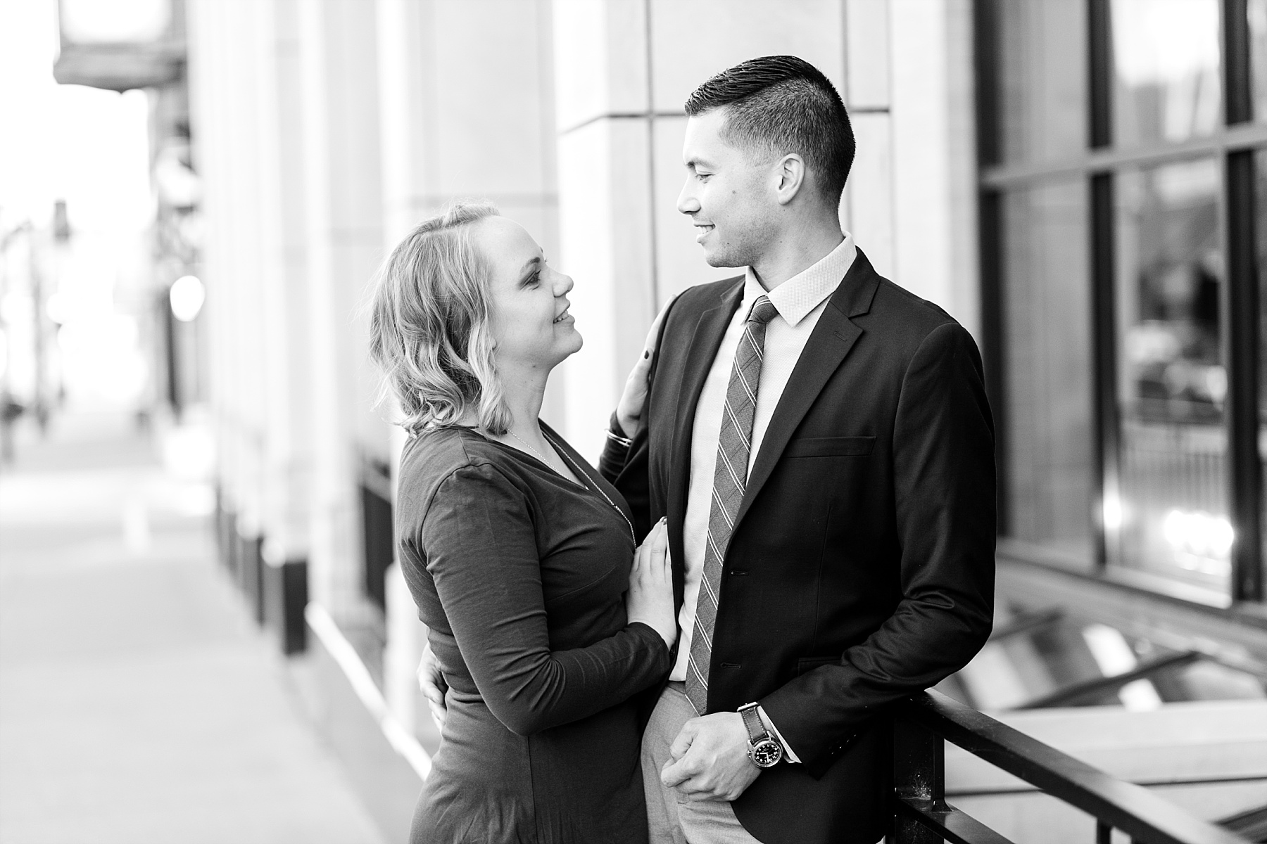 Black and white engagement photo  of a couple leaning on a bank.