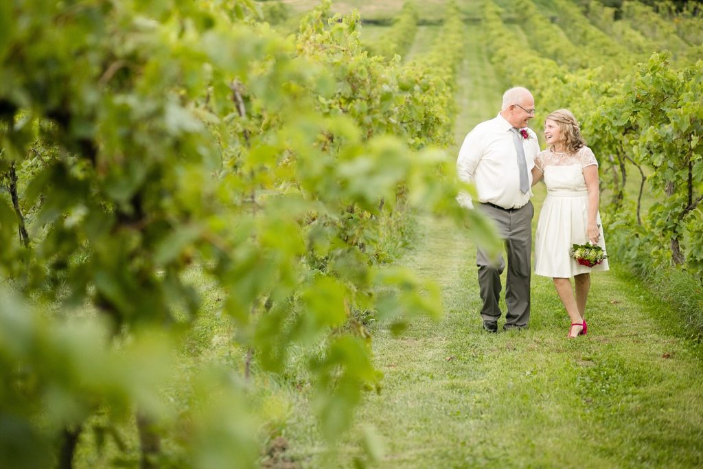 couple walking through a vineyard after eloping in Wisconsin.