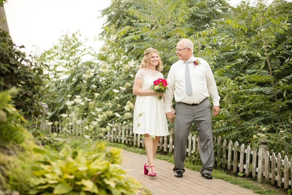 couple walking on a brick path through cottage winery and vineyard.