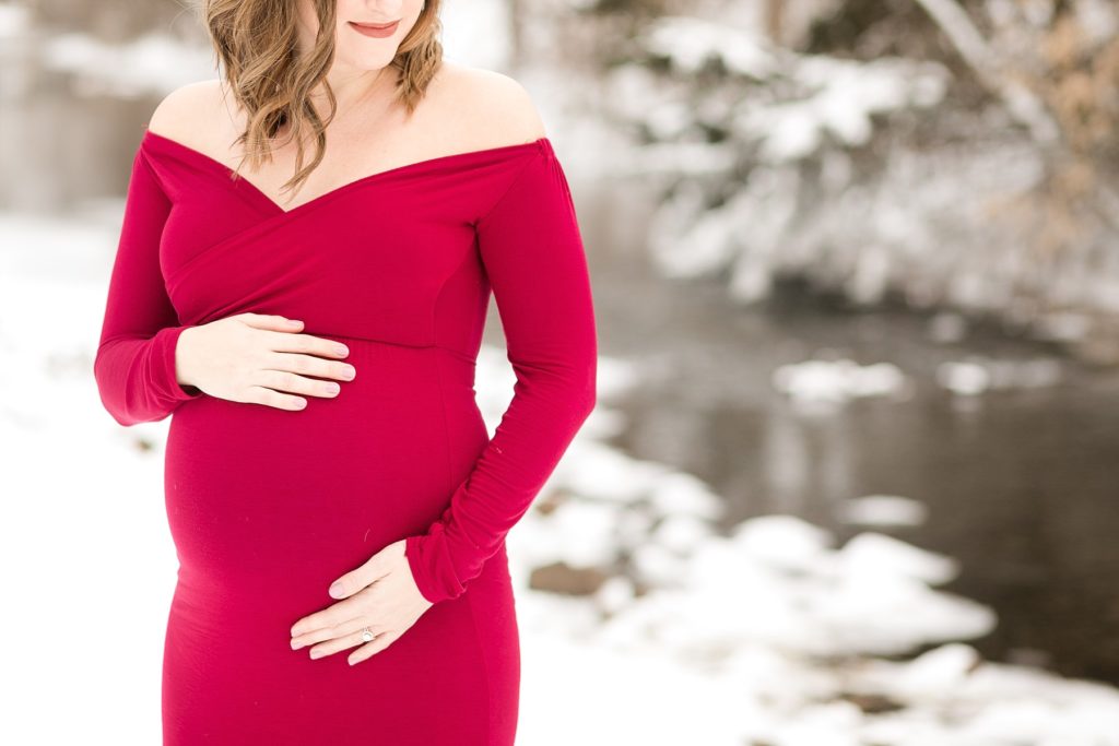 photo of Ashley in a red dress holding her belly