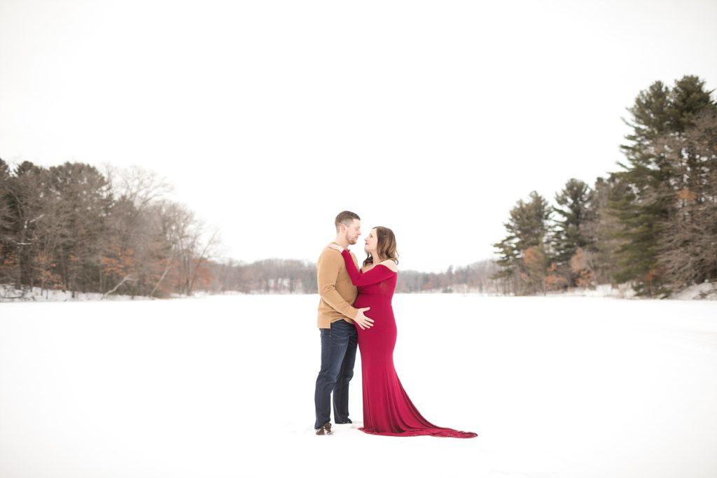 couple standing on a frozen lake in Wisconsin for their maternity photos