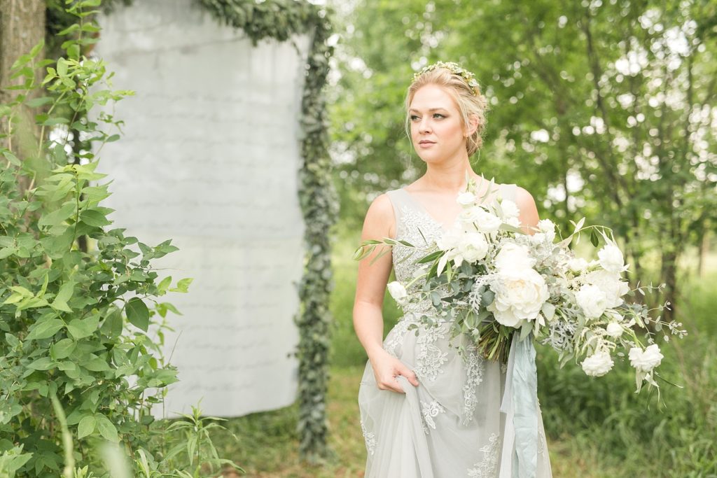 bride in a field with bouquet of flowers