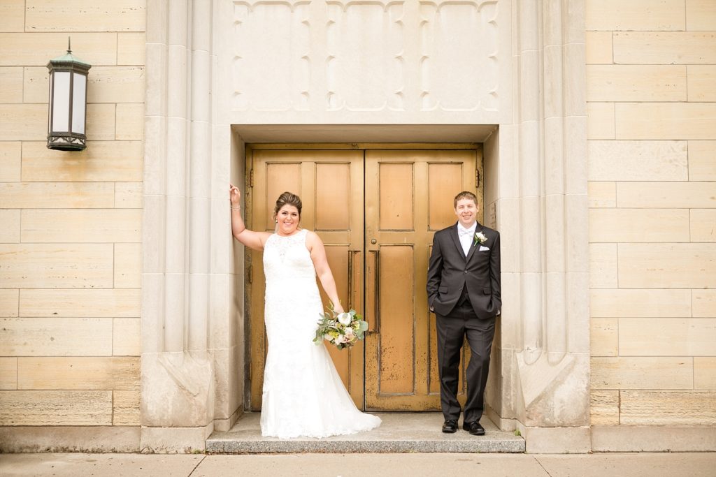 bride and groom outside gold doors at Wedding at St. Raphael & St. Patrick Cathedral in Dubuque