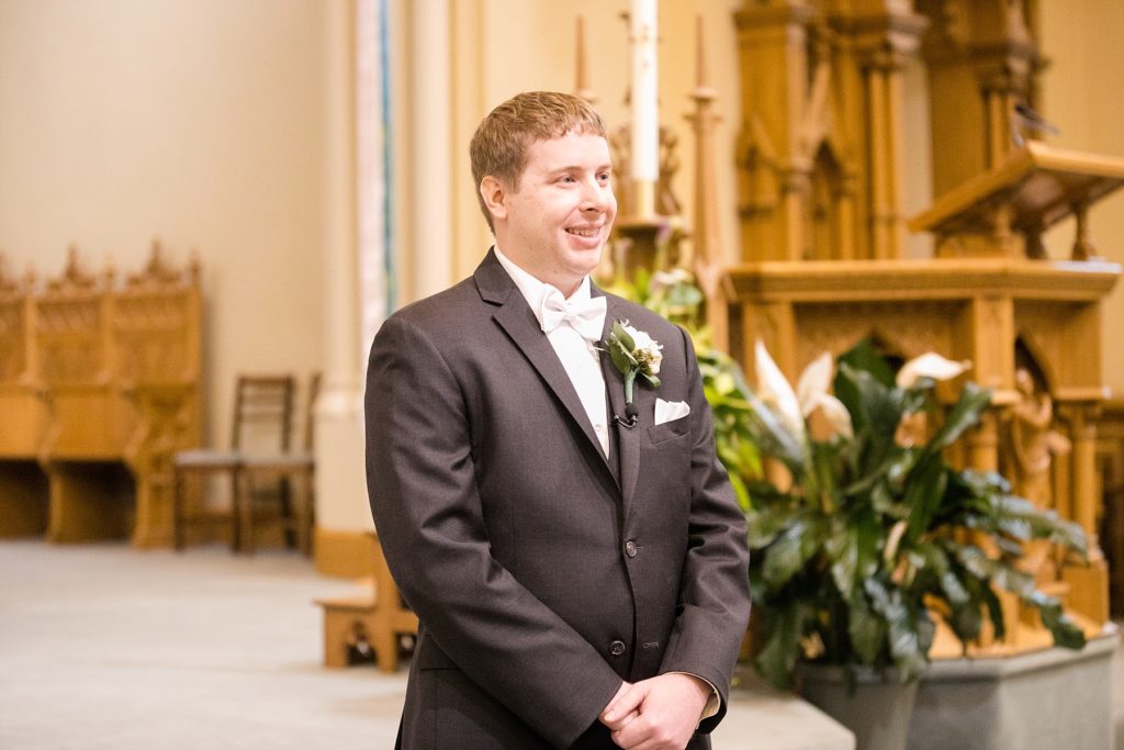 groom waiting for the bride to walk down the aisle at Wedding at St. Raphael & St. Patrick Cathedral in Dubuque