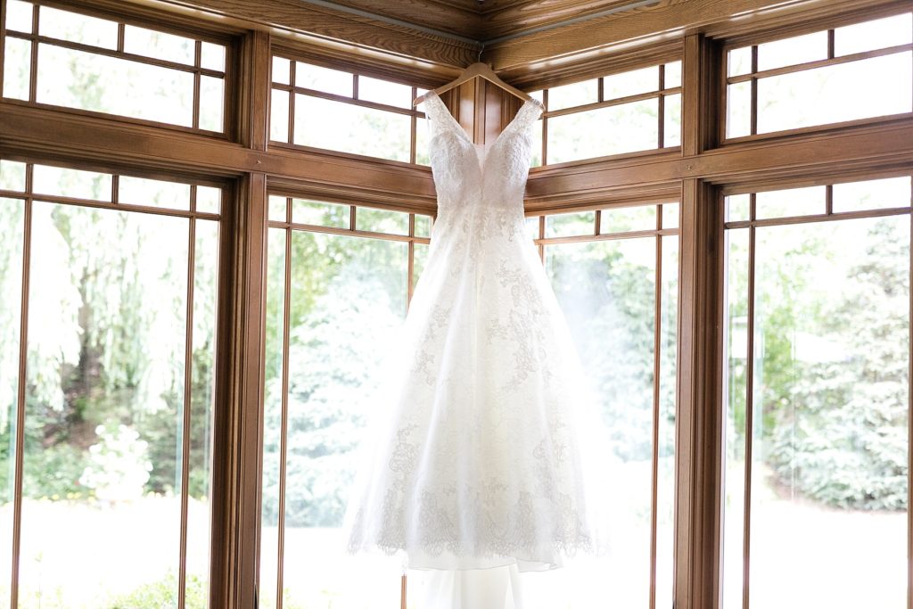bride's gown hanging near windows at The Florian Gardens in Eau Claire, WI