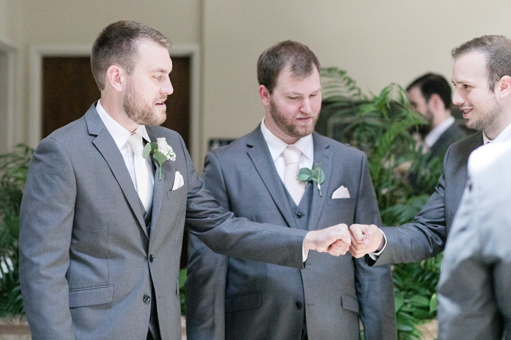 groom and best man fist bump before the ceremony at The Florian Gardens in Eau Claire, WI