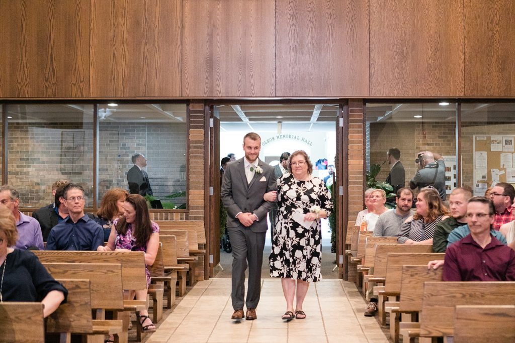 grooms mom walking groom down the aisle at Hope Lutheran Church in Eau Claire