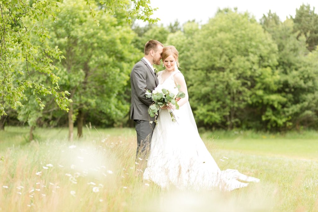 bride and groom in daisy field at wedding atThe Florian Gardens in Eau Claire