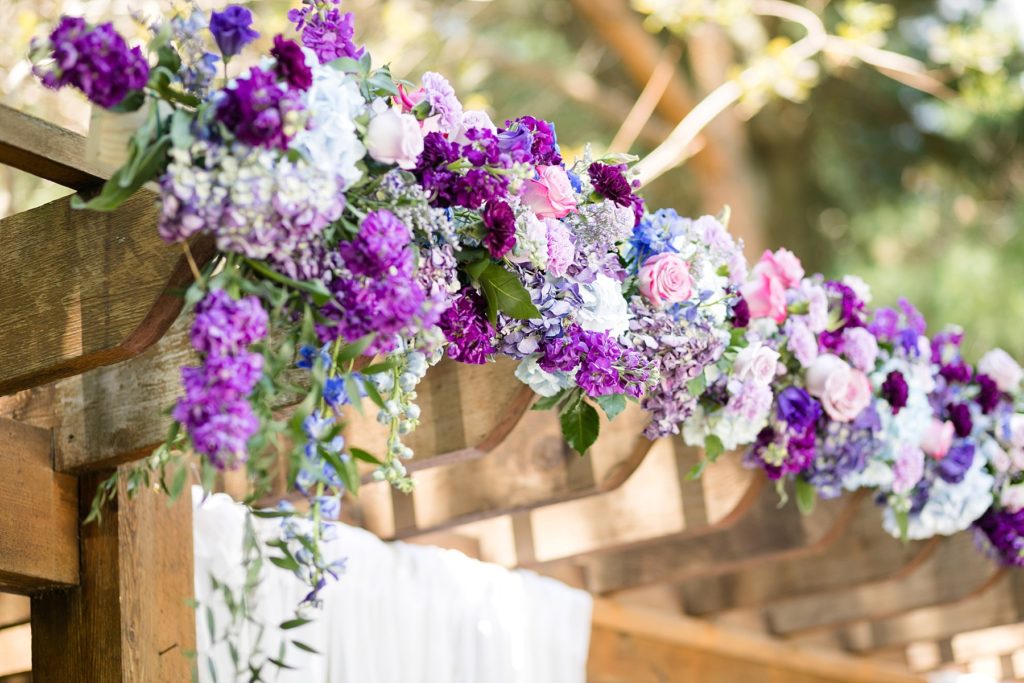 pergola with purple flowers by Allure Premiere Event Florists