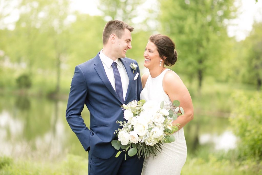 at the Florian Gardens in Eau Claire bride and groom share their first look infront of a lake