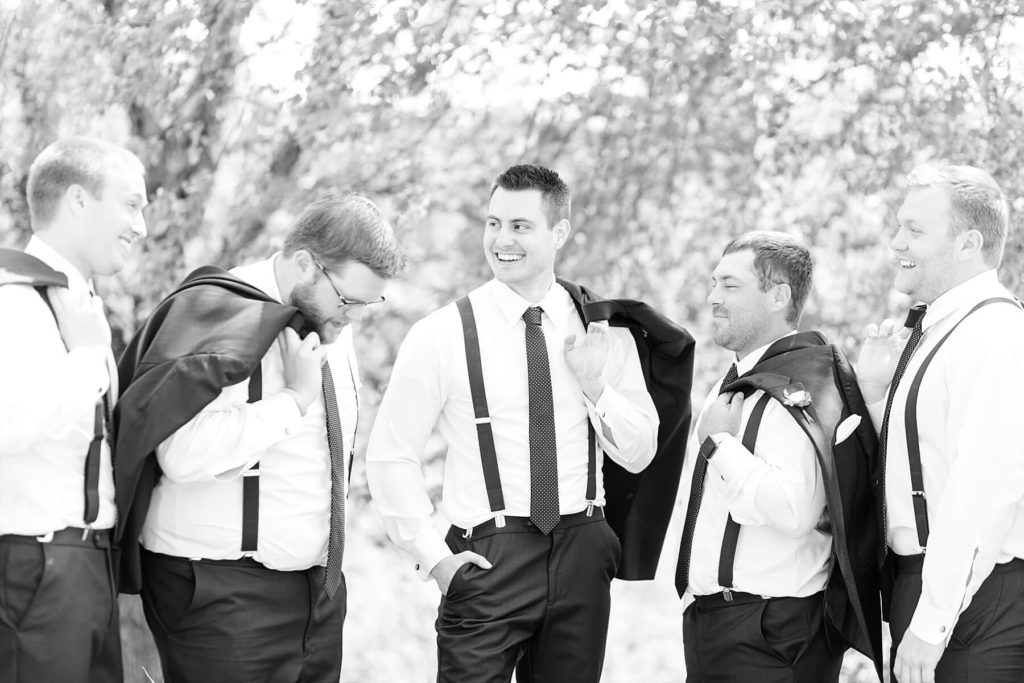 groom and groomsmen with their jackets off at the Florian Gardens in Eau Claire