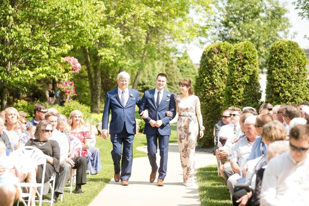 groom and parents walking down the aisle for the ceremony at the Florian Gardens in Eau Claire