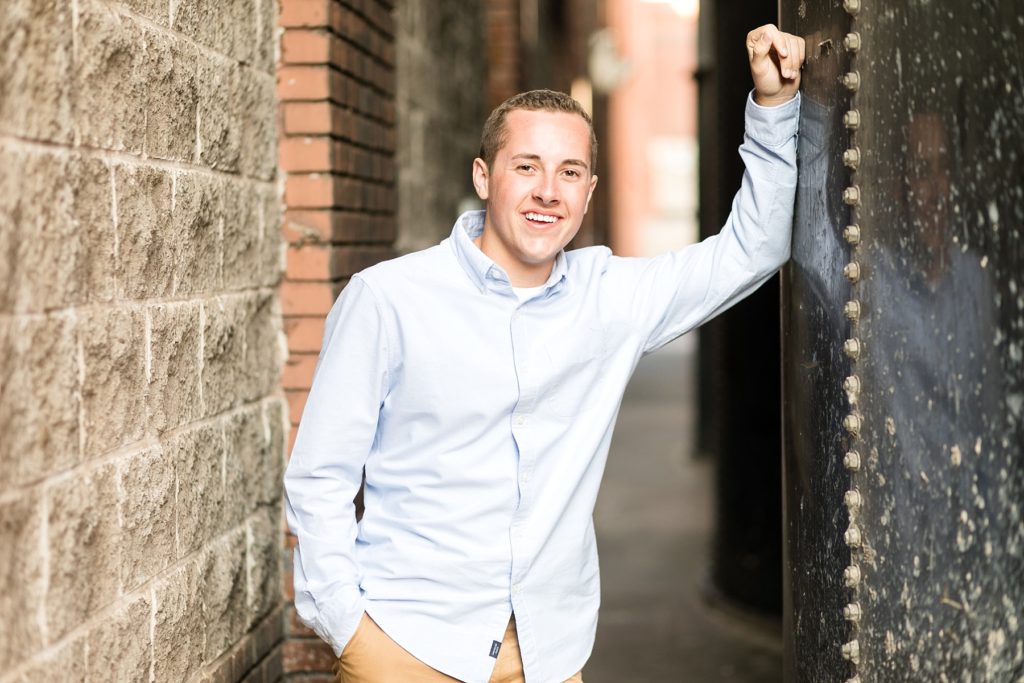 Urban location for senior photos, boy smiling at camera in Eau Claire, WI