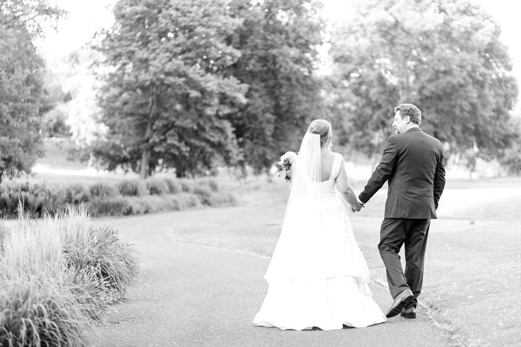 couple in black and white photo walking away from camera at the Eau Claire Golf & Country Club