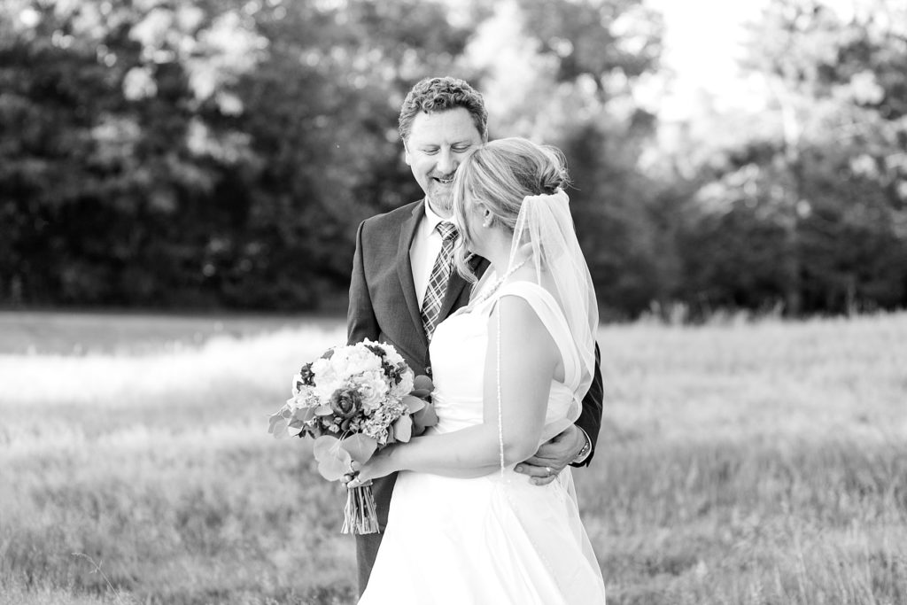 groom smiling at the bride in a black and white photo at the Eau Claire Golf & Country Club