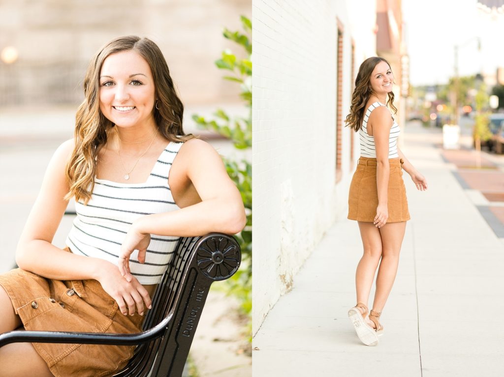sitting on a black bench and walking away from the camera downtown Eau Claire for her senior photos