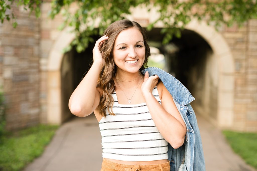 girl with a denim jacket over shoulder infront of a tunnel in Eau Claire wi