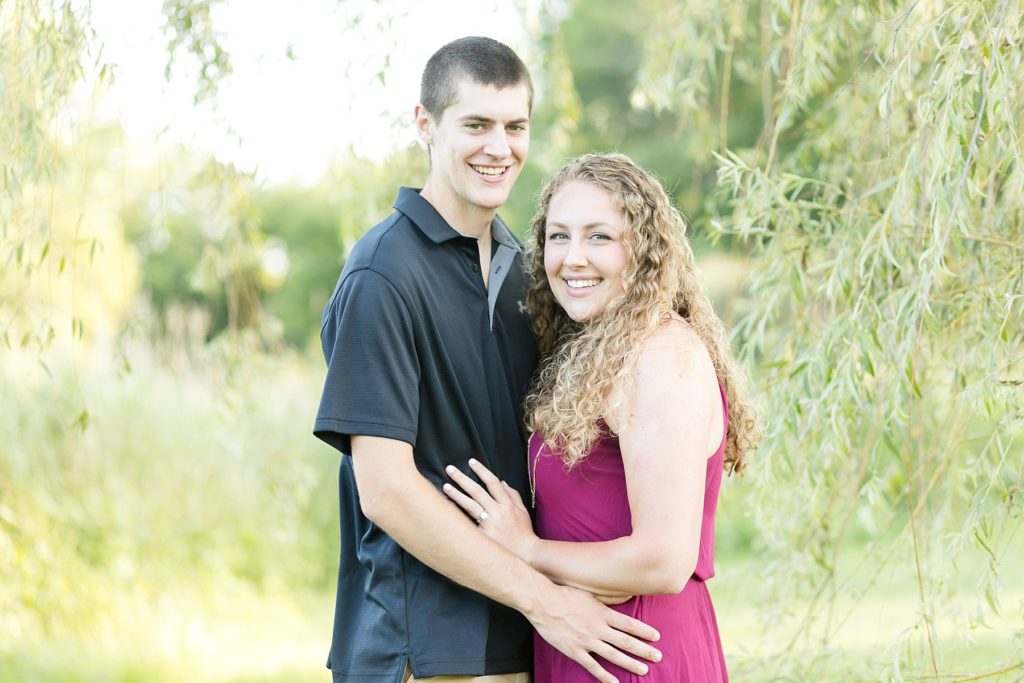 couple smiling at the camera for their Bloomer engagement pictures