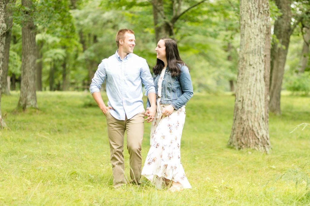 couple walking through tall grass in Brunet Island State Park for their engagement pictures
