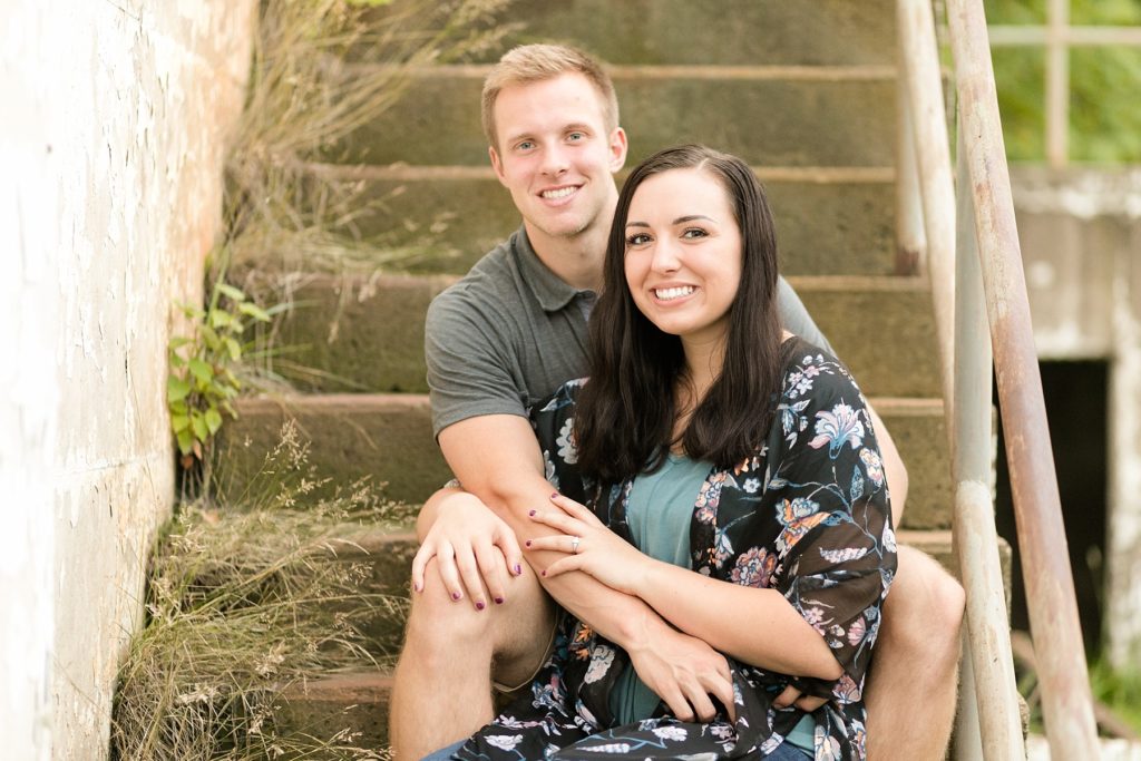couple sitting on stairs at an abandoned building in Cornell, WI for their engagement photos