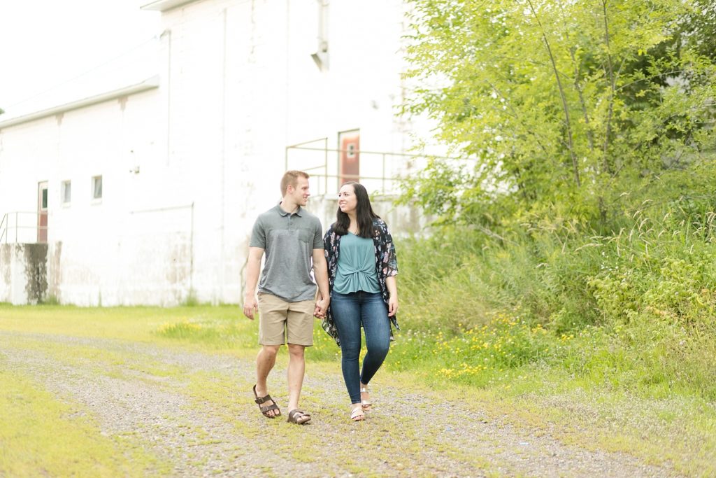 couple walking towards camera by an abandoned building in Cornell, WI for their engagement photos