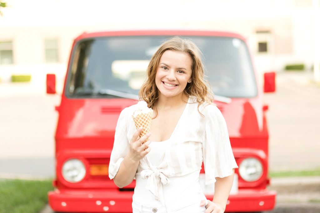 old red chevy van behind a girl eating an ice cream cone from Ramones in Eau Claire for her sweet 16 photo session