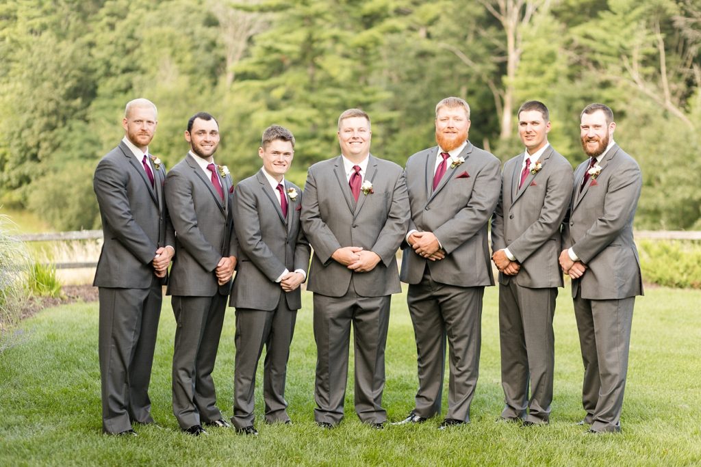 groom and groomsmen smiling at the camera at the Glacier Canyon Conference Center for a wedding at the Wilderness Resort in Wisconsin Dells