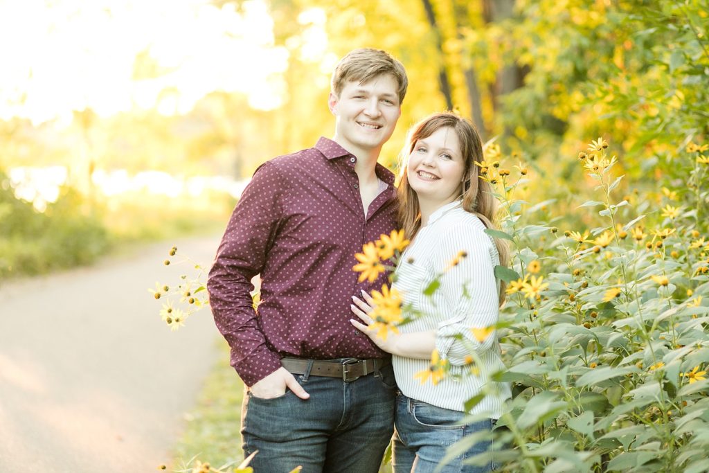 couple in tall yellow and black flowers near the UW Campus in Eau Claire