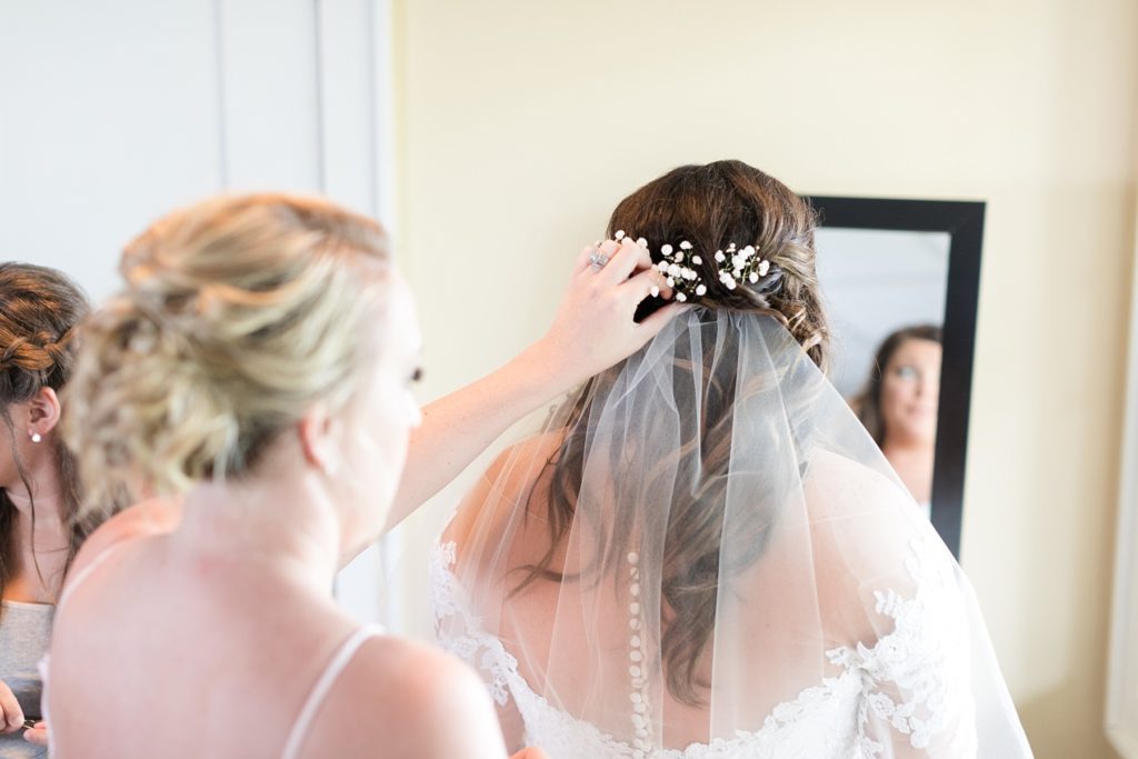 maid of honor placing the veil in the brides hair at Lake Wissota Golf & Events
