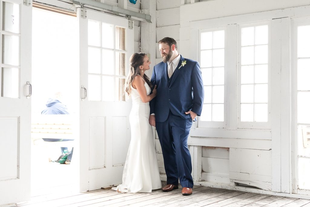 bride and groom in a white boathouse at The Beacons of Minocqua on their wedding day