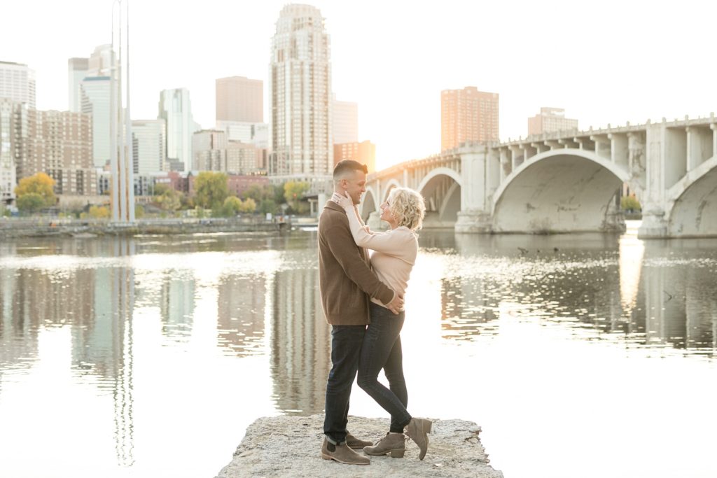 couple standing near the bridge at St. Anthony Main in Minneapolis for their engagement photos
