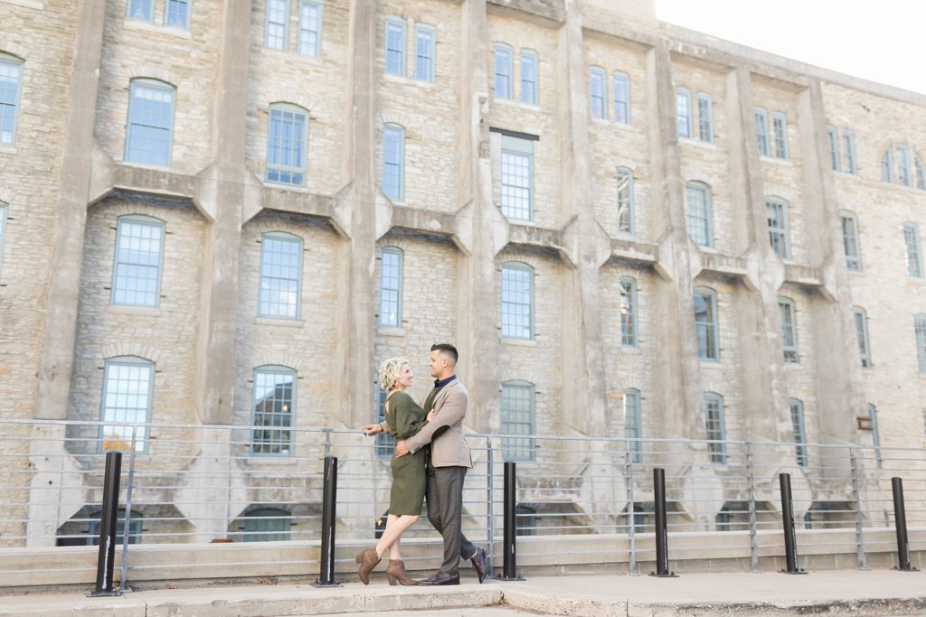 couple near the Pillsbury building in Minneapolis for their engagement photos in St. Anthony Main