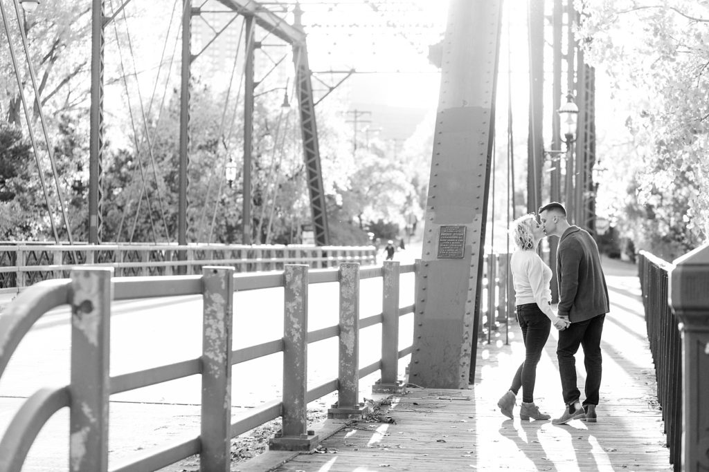 couple on a bridge for their fall engagement session in Minneapolis at St. Anthony Main