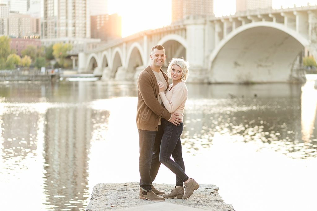 couple overlooking the bridge for their fall engagement session in Minneapolis at St. Anthony Main