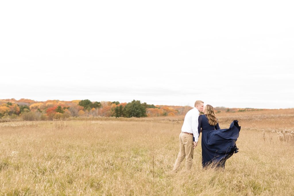 couple near the Dave Obey center by the Ice Age Trail in a field for their woodsy Wisconsin engagement session