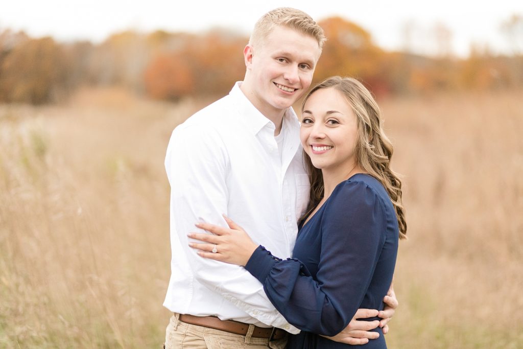 couple smiling at the camera for their woodsy Wisconsin engagement session