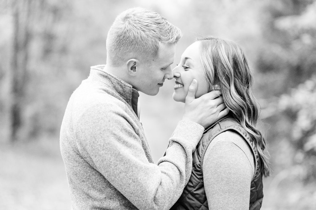 couple kissing in a black and white photo for their woodsy Wisconsin engagement session
